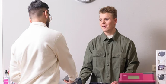 Retail medewerker werkt aan de kassa
