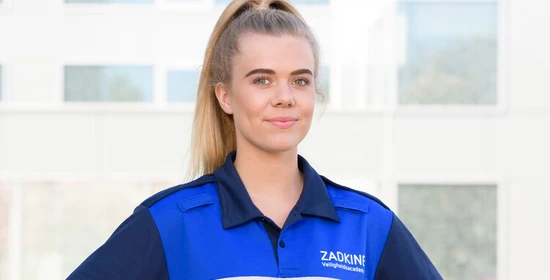 Student Handhaver Toezicht en Veiligheid poseert in uniform.
