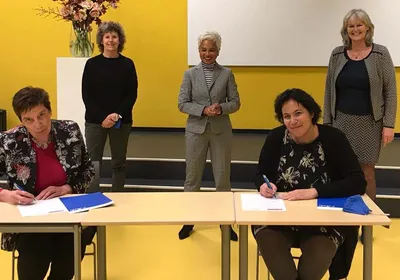 Ingrid van Steenhoven (links) en Ingrid Tuinenburg (rechts) tekenen de hernieuwde samenwerkingsovereenkomst. Op de achtergrond v.l.n.r.: Andrea van der Schoot (Albeda), Diantha Rumahlewan (Zadkine) en Aly Dassen (Albeda)