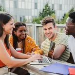 Jongeren zitten op dakterras met laptop