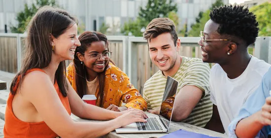 Jongeren zitten op dakterras met laptop