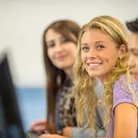 lachende vrouwwelijke student achter computer