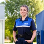 Student Handhaver Toezicht en Veiligheid poseert in uniform.