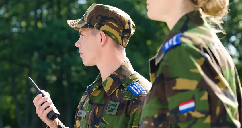 Studenten beveiliger Koninklijke Marechaussee doen een praktijkles in het bos.
