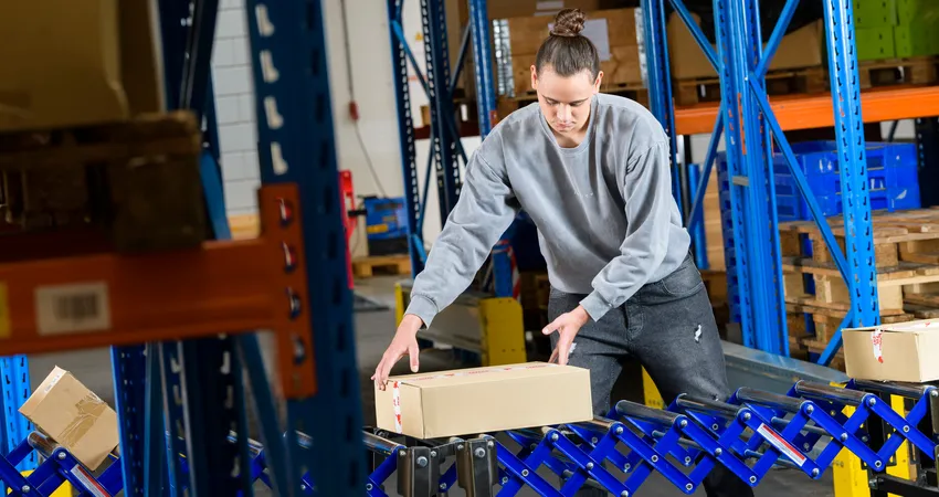 Student Logistiek Medewerker werkt met transportband