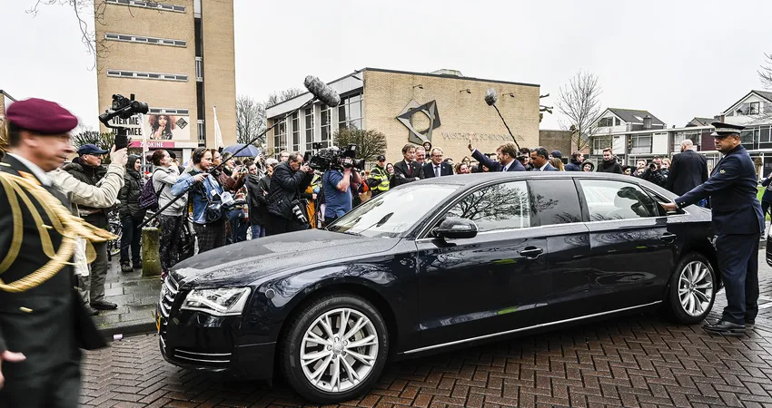 Koning Willem-Alexander omringt door pers bij de opening Jubileumjaar Vakschool Schoonhoven