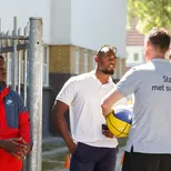 2 jonge mannelijke studenten Assistent Dienstverlening in een sportomgeving met bal staan tegenover elkaar